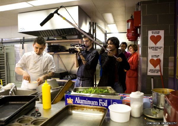 Things get hot in the kitchen while Iron Chef Douglas McNish prepares his entry while CUTVs Irfan Ahmed and Arien Haque record the proceedings. In the background, CSU president Amine Dabchy and President Judith Woodsworth look on.
